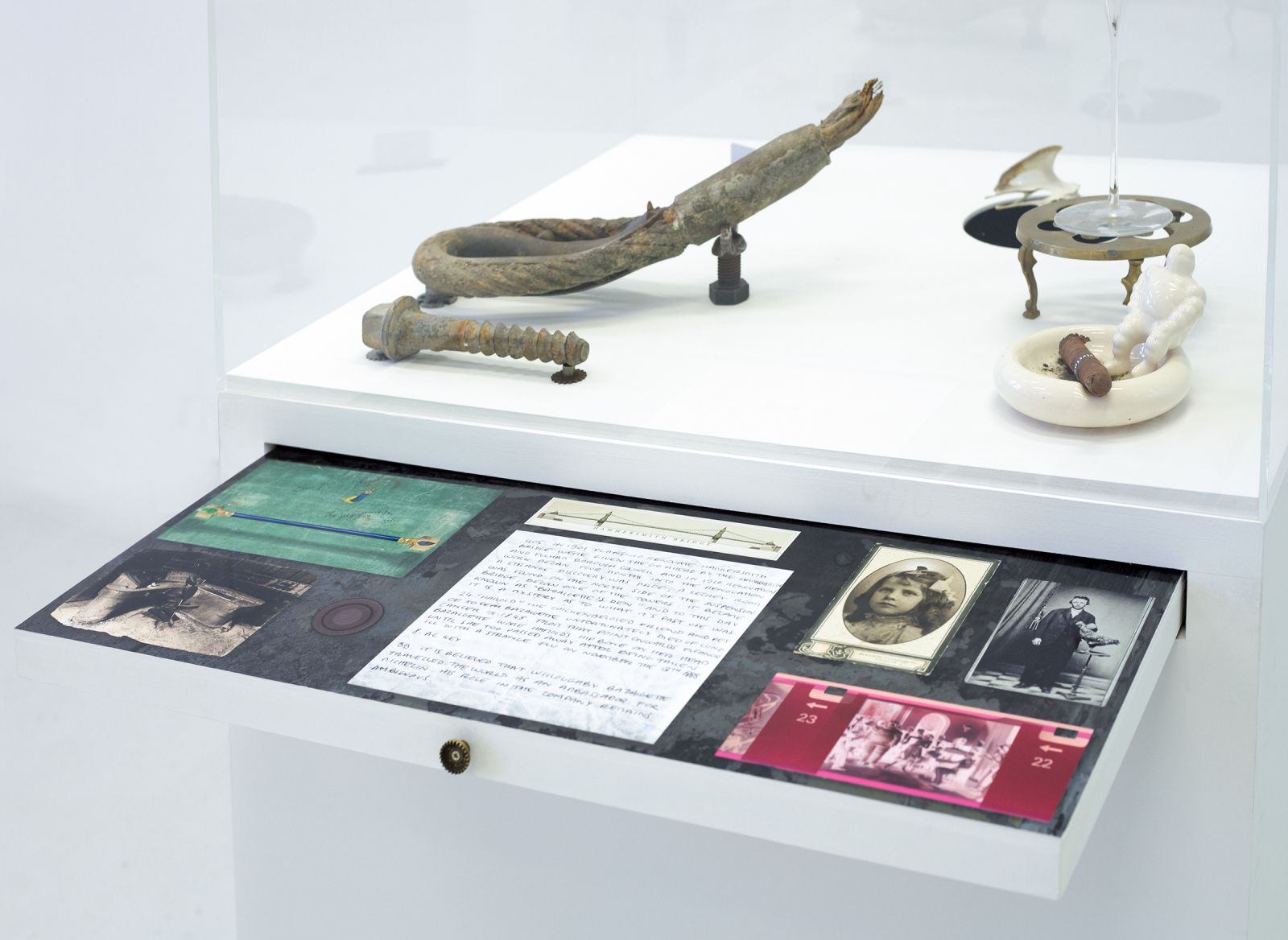 a tray in the cabinet is opened revealing several archive prints